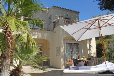 Left front side of the finca beside the pool with loungers and parasol