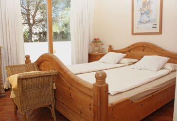 Bedroom with rustic wooden double bed and wall window