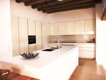 White open kitchen beside dining zone and lounge