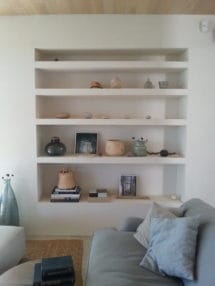 Wall shelf with decorative elements beside the sofa