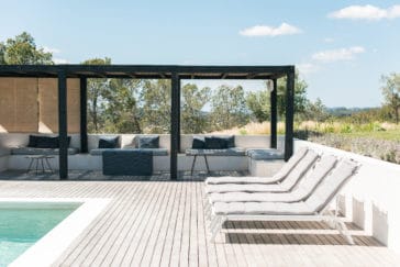 Spacious roofed chill out area at the pool with sofas and little tables