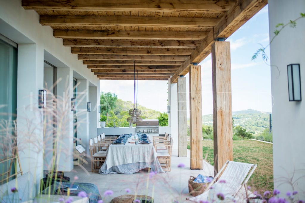 Porch with typical Blakstad wooden beams and big laid dining table and