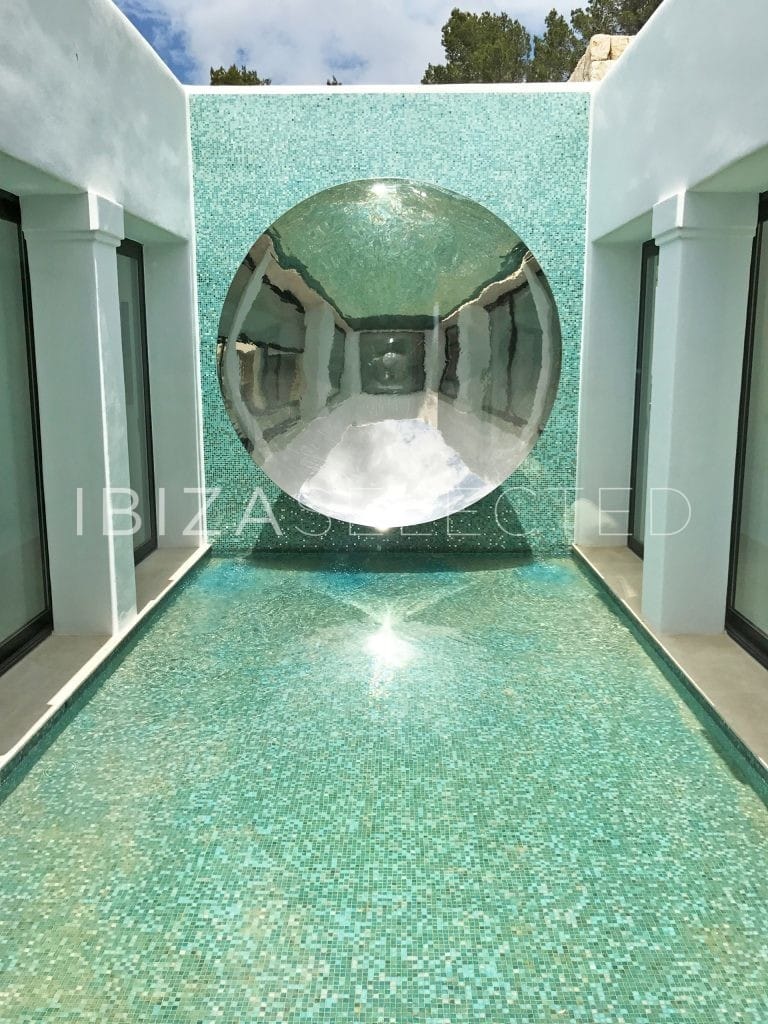 Interior patio designed with green mosaic walls and a half crystal ball