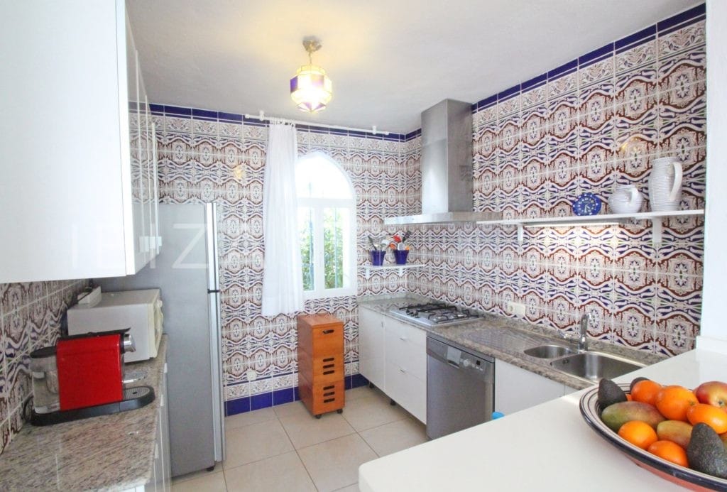 Kitchen with patterned tiles and arabic glass lamp