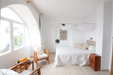 Double bedroom with mosquito net and big arched window