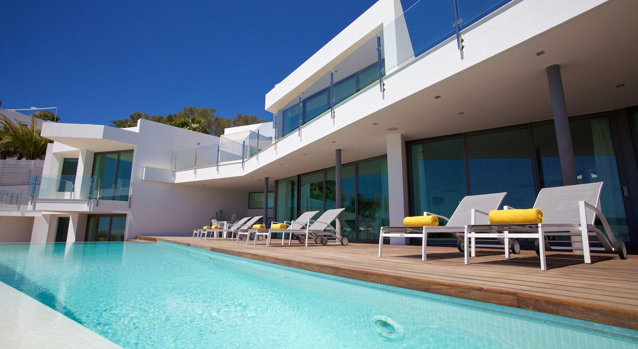 Infinity pool in front of veranda with loungers