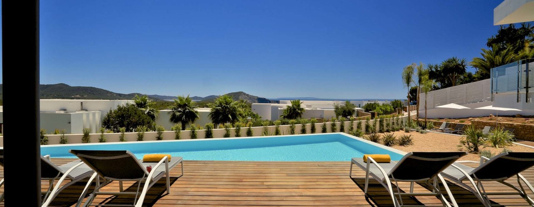 Wooden floor veranda beside the pool with loungers