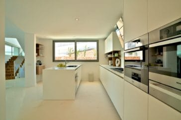 Modern open white kitchen with window and kitchen centre