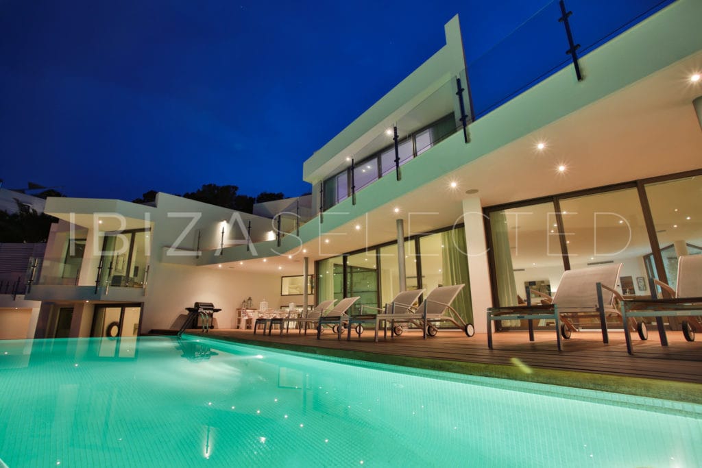 Look from illuminated infinity pool to veranda and terraces