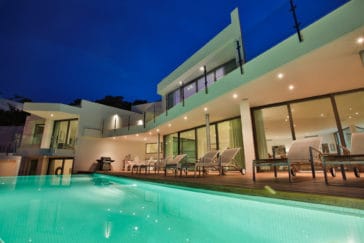 Look from illuminated infinity pool to veranda and terraces