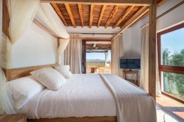 Bright Blakstad-style bedroom with huge window and window door open to private terrace