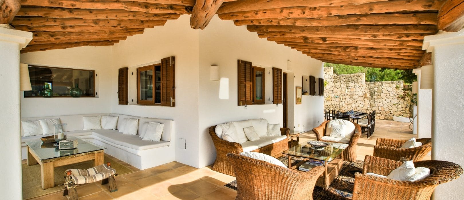 Veranda with a seating corner on one side and rattan suite and dining table on the other side