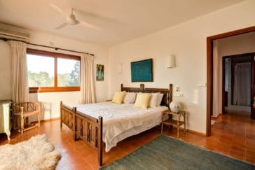 Rustic double bedroom beside wooden bed and window