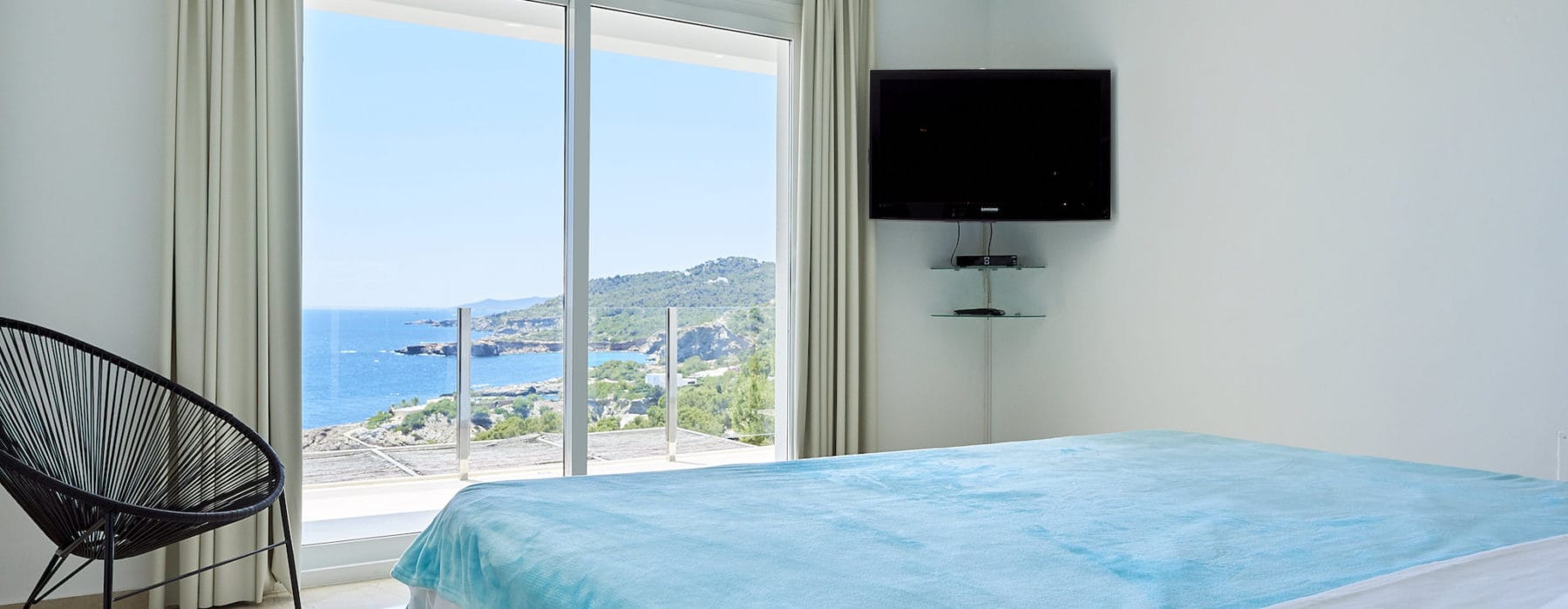 Double bedroom with stunning sea view through door window and glass front terrace