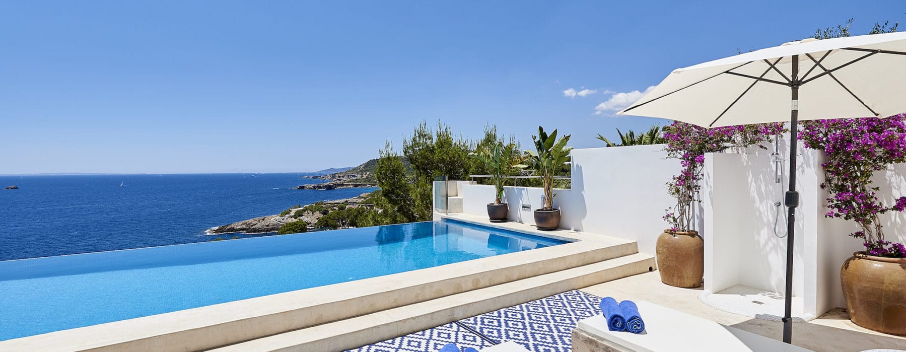 Infinity pool with sun loungers and magnificent view to sea and coast