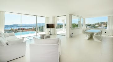 Living room with glassfront windows and panoramic views to Ibiza's Talamanca Bay