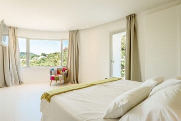 Double bedroom with window front and views to the hills