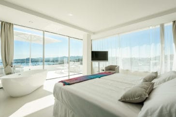 Double bedroom with corner glass front that offers an 180º view to bay and hills, separate bathtub and private terrace