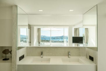 Modern bathroom with 2 square sinks and big mirror that reflects the Talamanca Bay