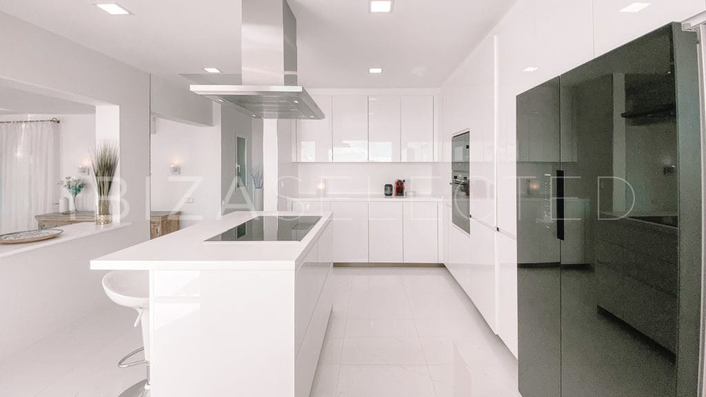 White kitchen with kitchen centre open to living room