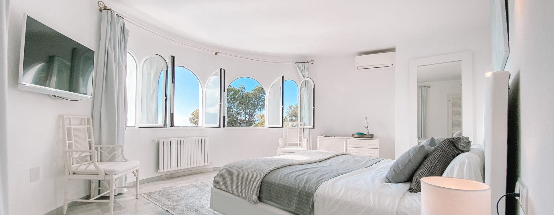 Double bedroom with round window wall in white design