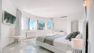 Double bedroom with round window wall in white design