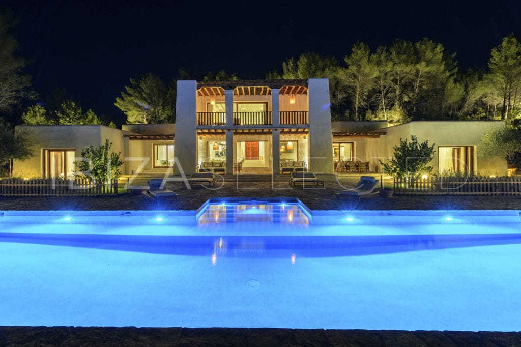 Front view at night of Blakstad-style villa with pool