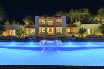 Front view at night of Blakstad-style villa with pool