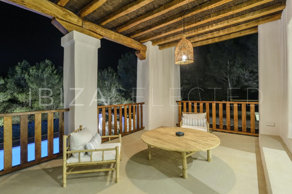 Private terrace with low table and two chairs of master bedroom at night