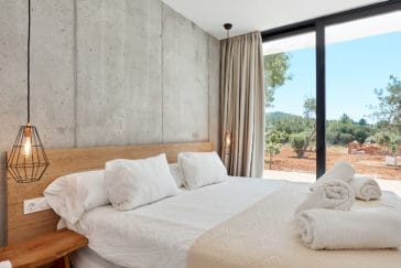 Rustic modern designed bedroom with glass wall door and view to farmland