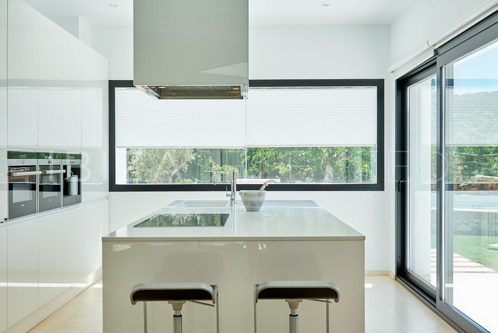 Kitchen centre of modern glass fronted kitchen in light beige