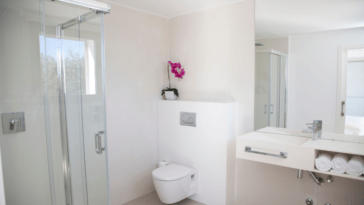 Bathroom in white design with shower and hanging toilet