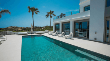 Pool terrace with square pool, two double bed sun loungers and modern design lounge chairs