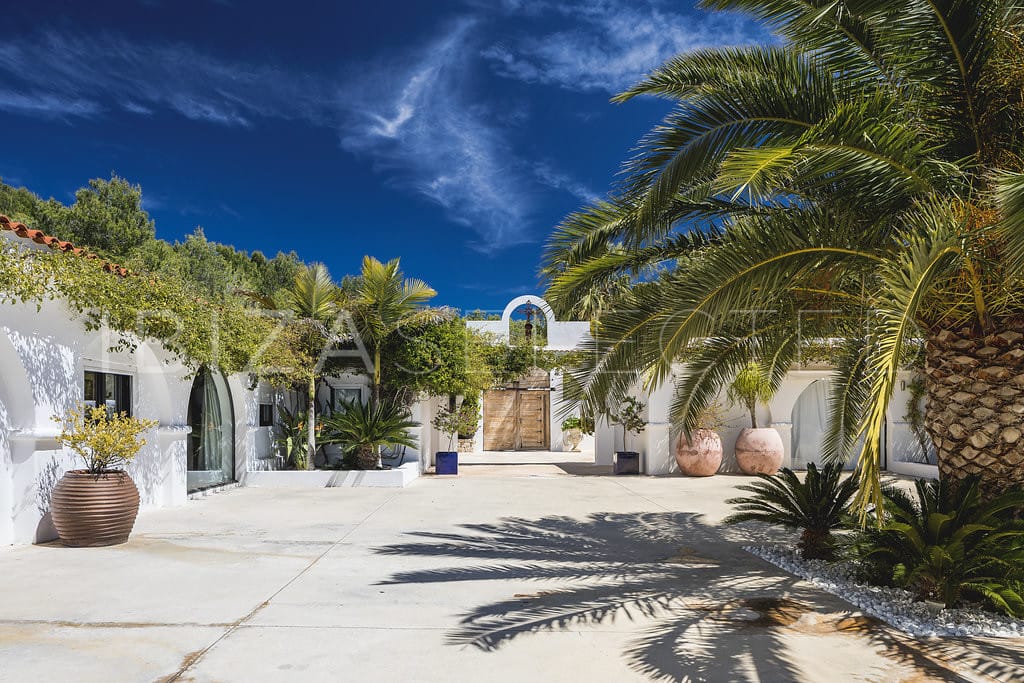 Square courtyard in Spanish hacienda-style with big palm tree in the centre
