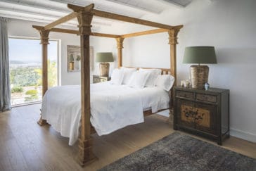Double bedroom in rustic style with large window that looks to garden