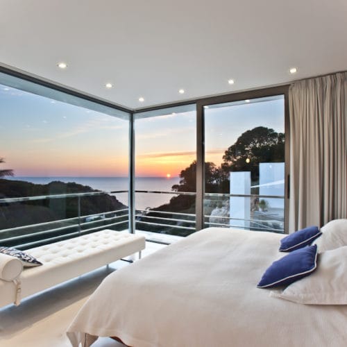 Master bedroom with corner glass front that offers views of the sunset
