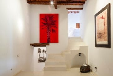 Modern white stairwell with a little hall with 2 paintings that connects 2 levels