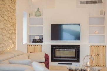 Wall in front of couch with wall rack, TV and closed fireplace