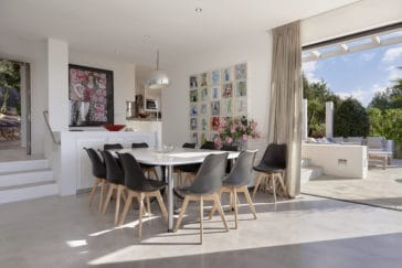 Dining table in front of half open kitchen and beside open terrace