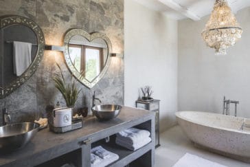Bathroom in silver metallic design with round stone bathtub