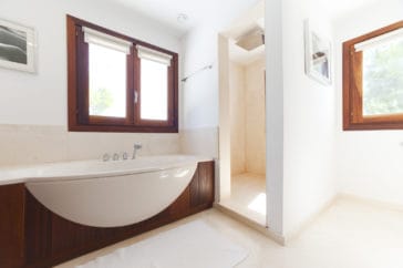 Bathroom with modern wooden style bathtub and corner shower