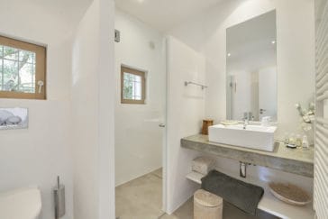 Bathroom with white square sink vanity and hidden walk in shower