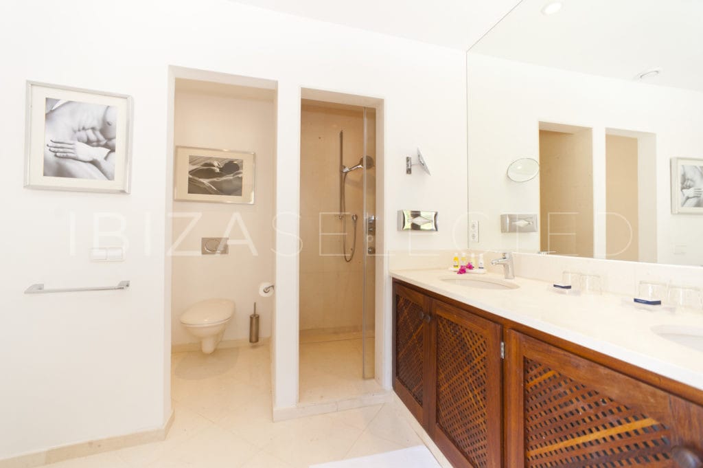 Bathroom with double vanity with wooden cupboards, toilet and shower