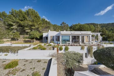 Front view from the terraced garden of square design villa embedded in countryside
