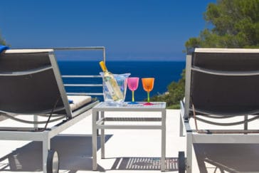 2 sun loungers on a terrace overlooking the sea