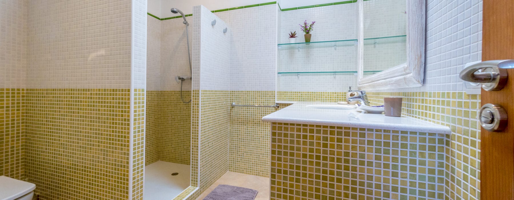 Bathroom with shower in yellow-green mosaic tiles design