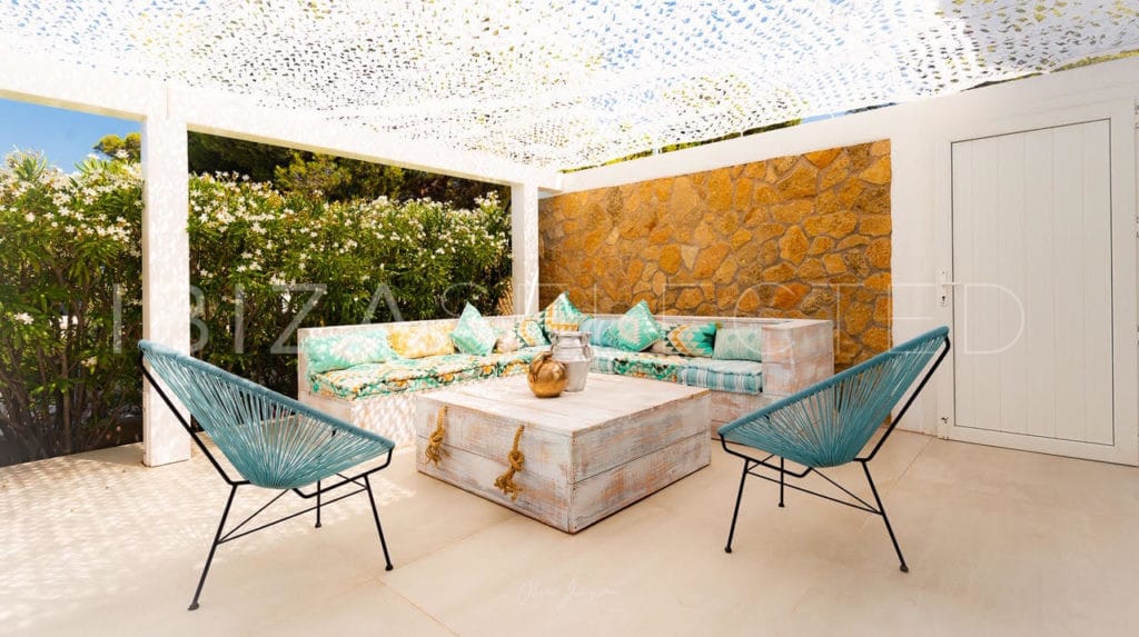 Outdoor corner sitting area with 2 chairs roofed with white patchy fabric