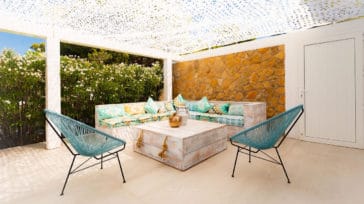 Outdoor corner sitting area with 2 chairs roofed with white patchy fabric