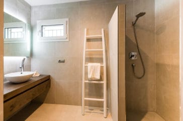 Bathroom with wooden vanity, walk-in shower and little window