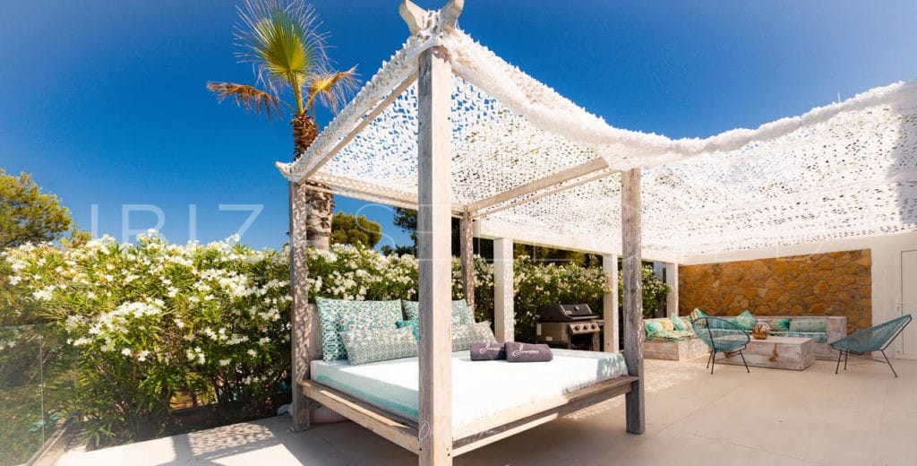 Outdoor relax area with double sunbed and lounge suite covered by a white patchy fabric
